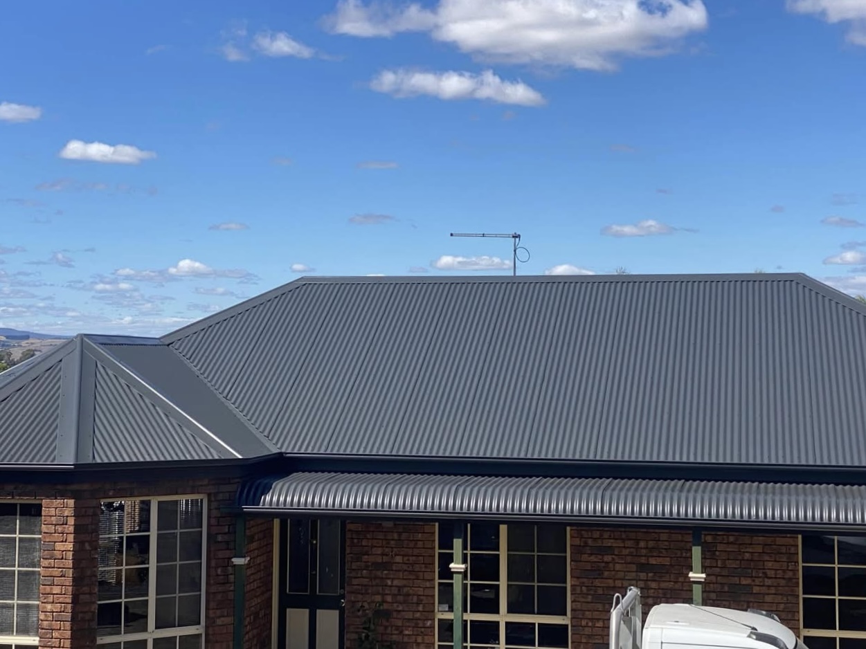 Same corrugated metal roof after charcoal Dulux AcraTex respray