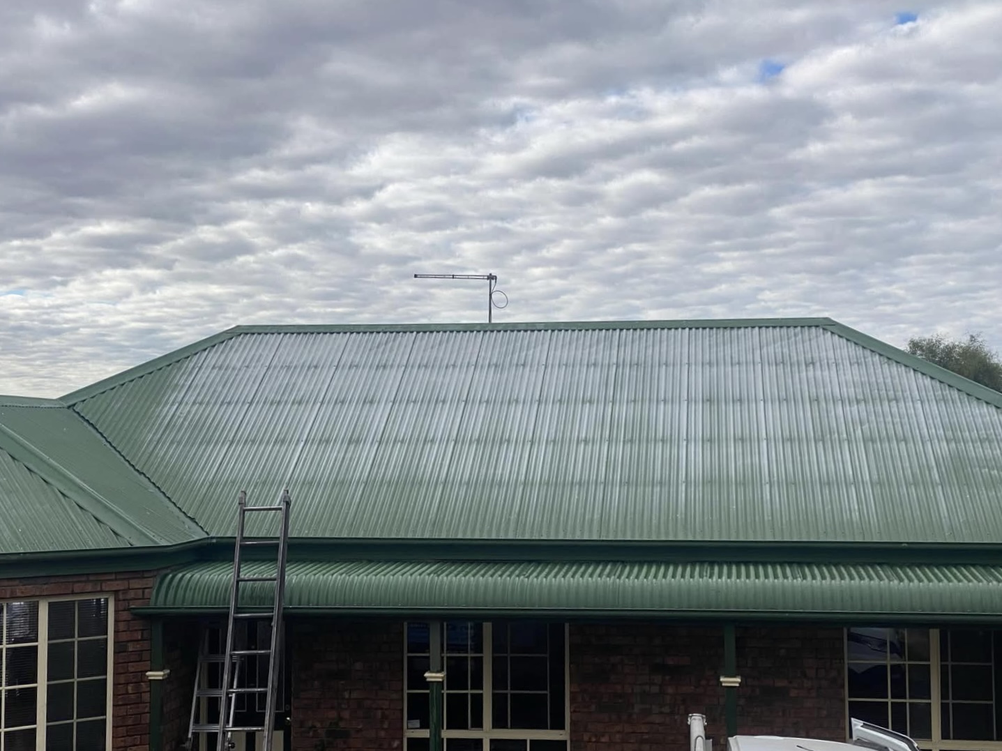 Faded green corrugated metal roof before respray